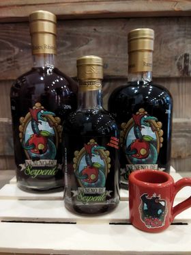 Três garrafas de licor Veneno de Serpente com um copo pequeno vermelho