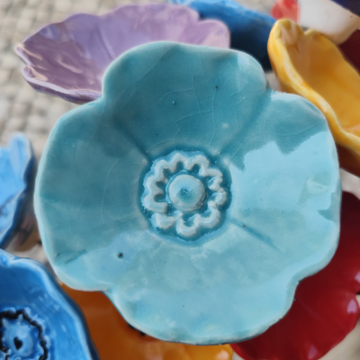 Prato cerâmico azul formato de flor com detalhes em relevo no centro