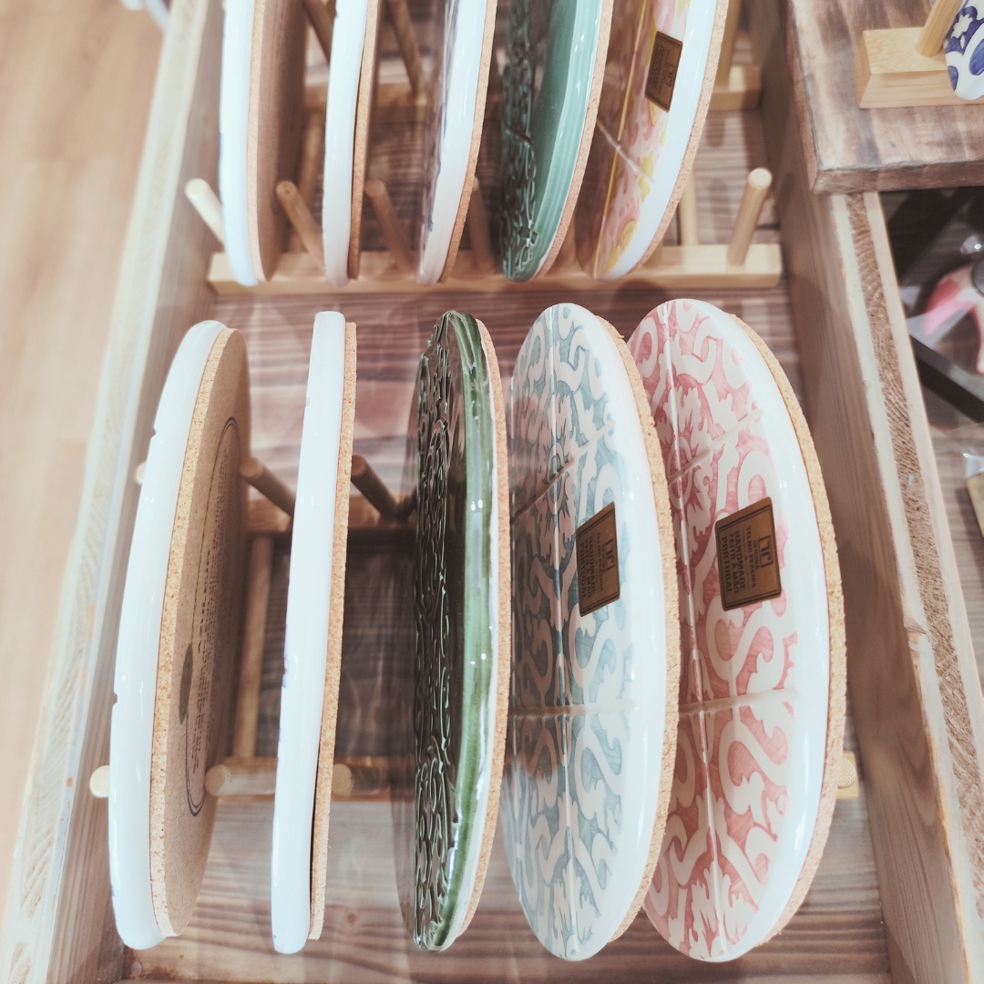 Tabuleiros de cerâmica coloridos em suporte de madeira