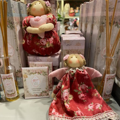 Bonecos de tecido em vestidos florais vermelhos com aromatizadores e caixas decorativas