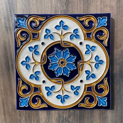 Azulejo decorativo quadrado com padrão floral azul e dourado