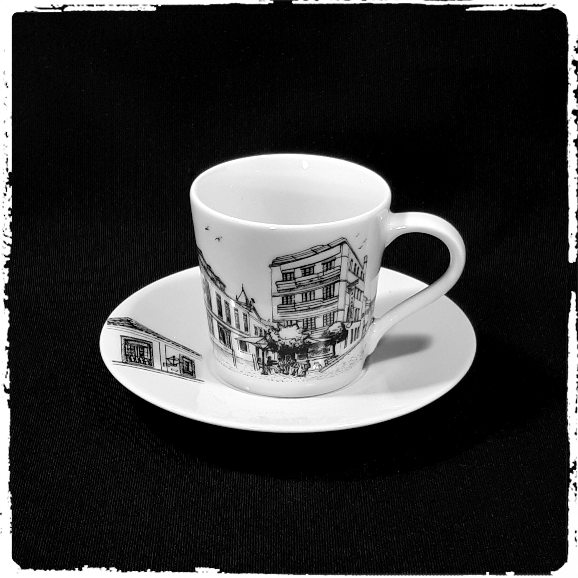 Chávena de café branca com pires e ilustrações a preto