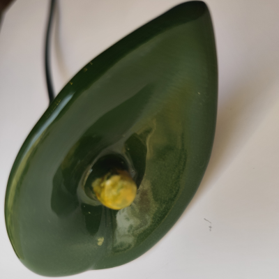 Objeto decorativo verde em forma de folha com caule amarelo