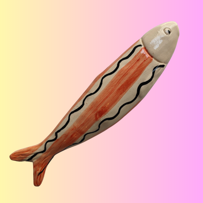 Peixe decorativo de cerâmica com riscas alaranjadas e pretas onduladas