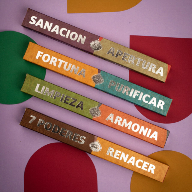 Quatro pacotes coloridos de incenso com textos em espanhol sobre cura, fortuna, limpeza, harmonia e renascimento