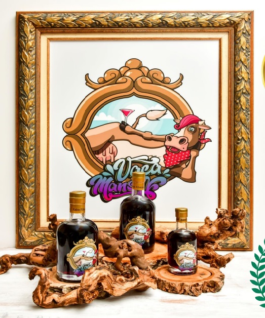 Garrafa de licor com rótulo colorido sobre madeira, quadro com desenho de vaca