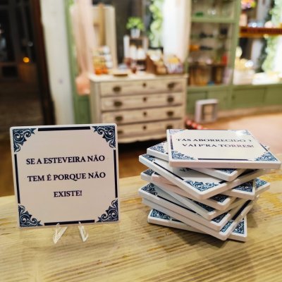placas decorativas de cerâmica branca com texto em português em balcão de madeira