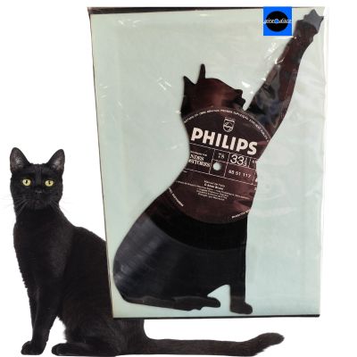 Vinil preto em forma de gato com etiqueta PHILIPS em embalagem transparente ao lado de gato preto real