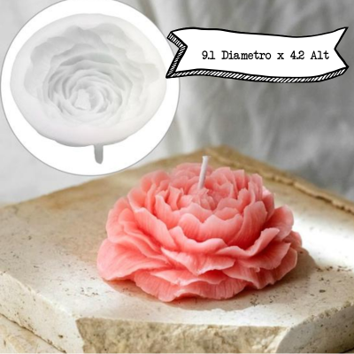 Vela rosa em forma de flor e molde de silicone branco ao fundo.
