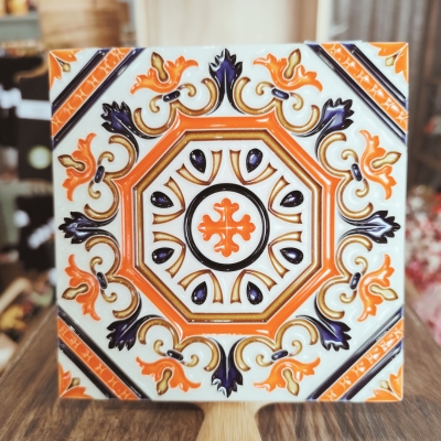 Azulejo ornamental quadrado em laranja, roxo, branco e dourado