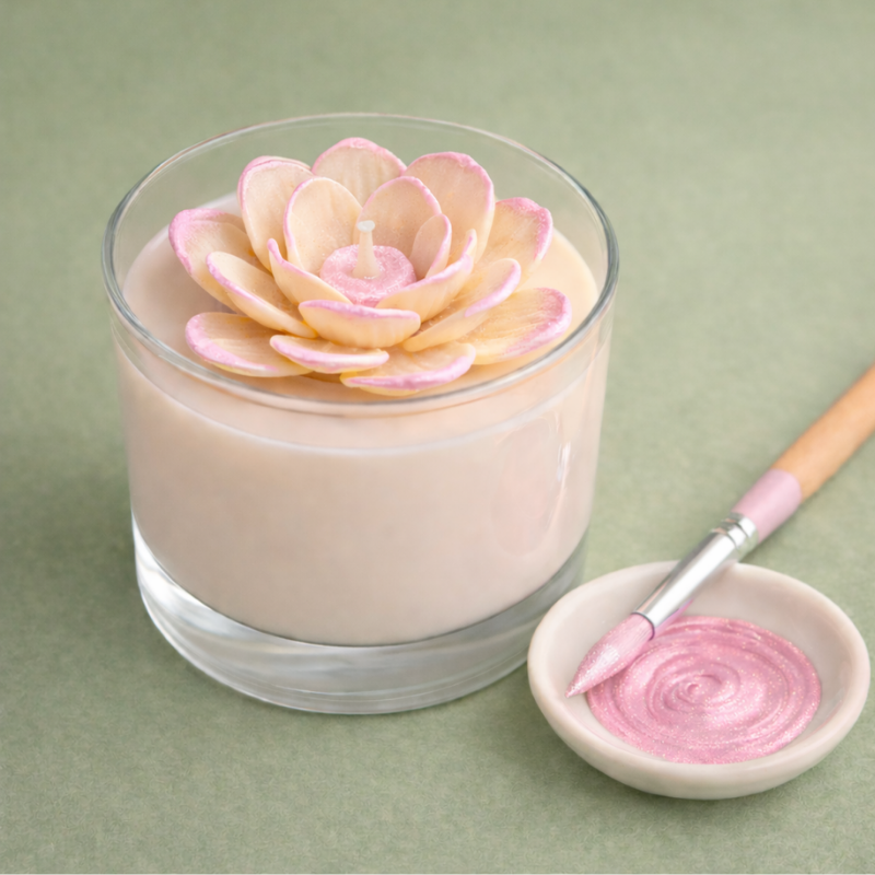 Vela em copo transparente com flor decorativa dentro e pincel com esmalte rosa