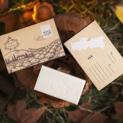 Produtos embalados vintage sobre suporte de madeira com folhas e erva seca ao fundo