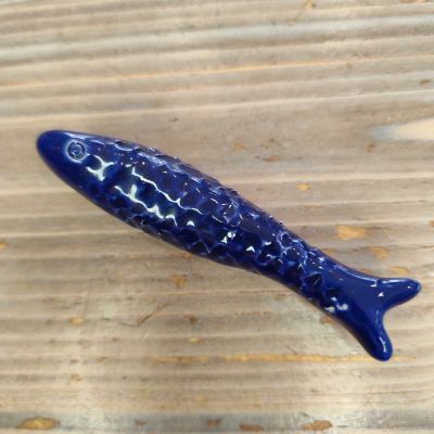 Peixe decorativo azul em cerâmica com textura sobre madeira clara
