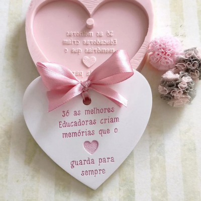 Pendente coração branco com texto rosa e laço rosa, caixa coração rosa e acessórios florais.