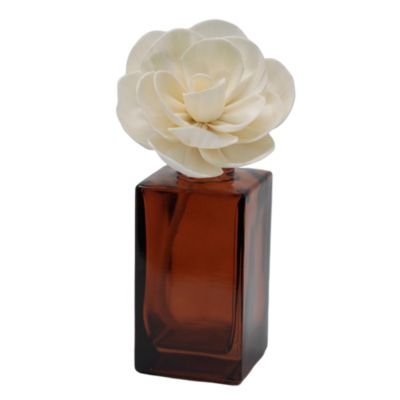 Dispositivo difusor de aromas com base em vidro castanho e flor decorativa branca