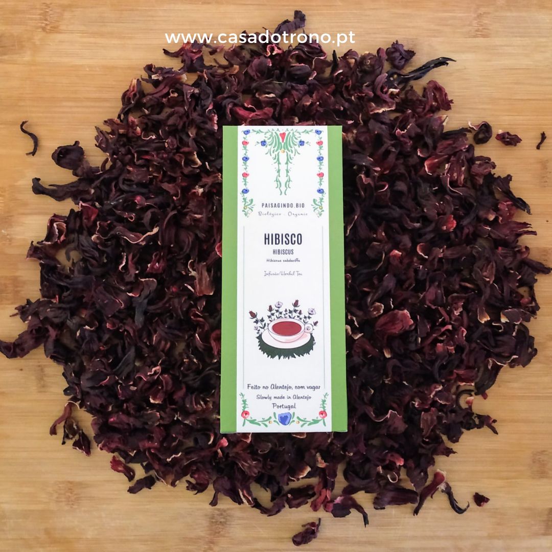 Pacote de chá de hibisco com pétalas secas em fundo de madeira