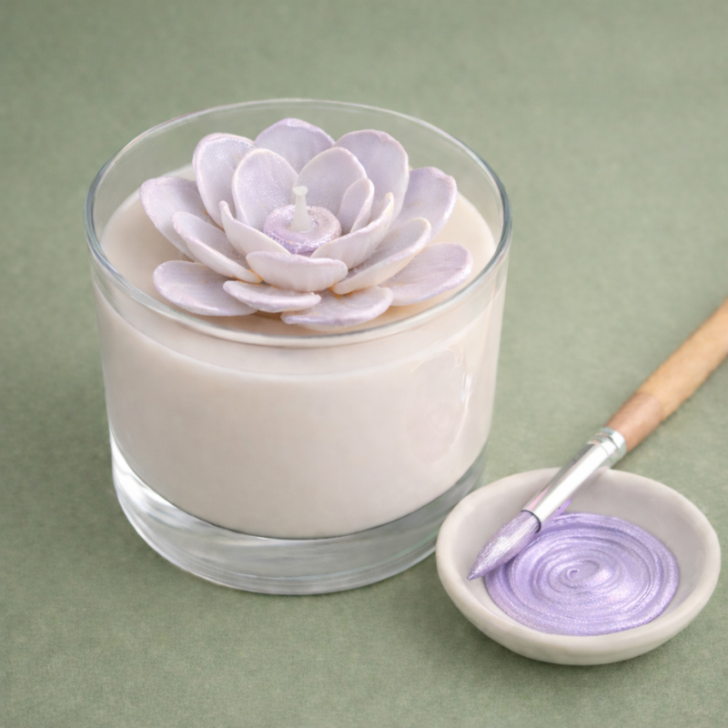 Vela decorativa com flor lilás e pincel de tinta lilás