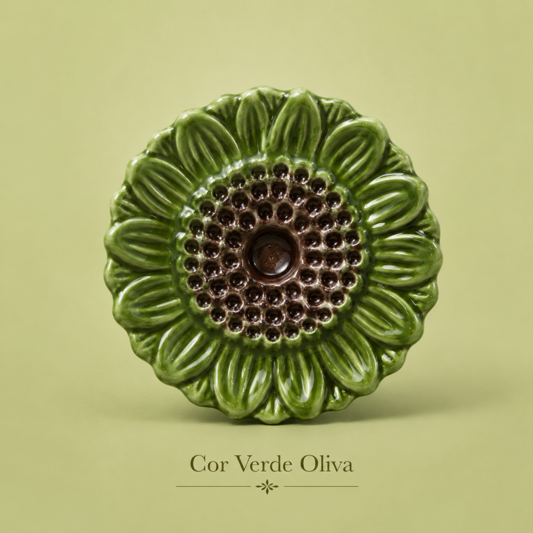 Flor decorativa de cerâmica verde oliva com centro castanho em fundo verde claro.