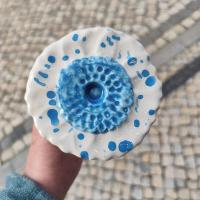 Objeto cerâmico redondo azul e branco com padrão em relevo
