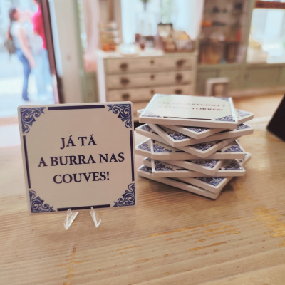 Azulejos decorativos brancos com moldura azul e texto em português