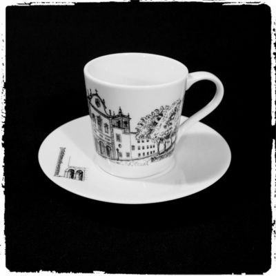 Conjunto de chávena e prato em porcelana branca com desenho de edifícios históricos em preto