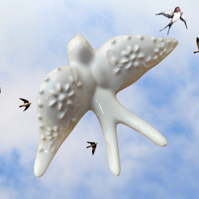 Escultura branca em cerâmica de andorinha com textura floral, sobre fundo azul com andorinhas voando