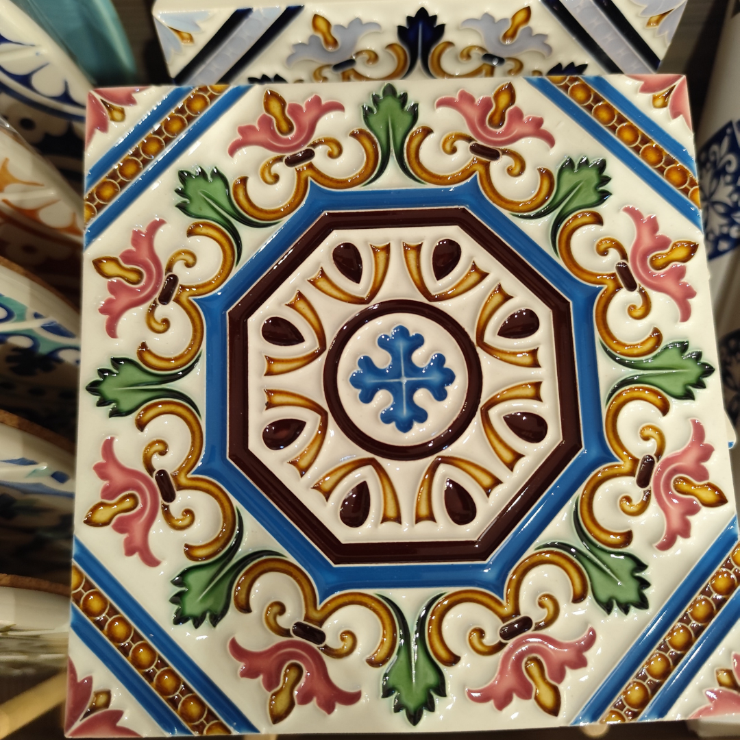 Azulejo cerâmico decorativo com padrão floral e geométrico em várias cores