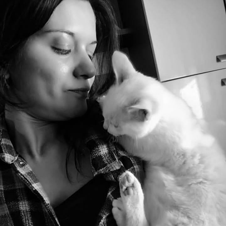 Mulher com camisa xadrez segurando gato de pelo claro