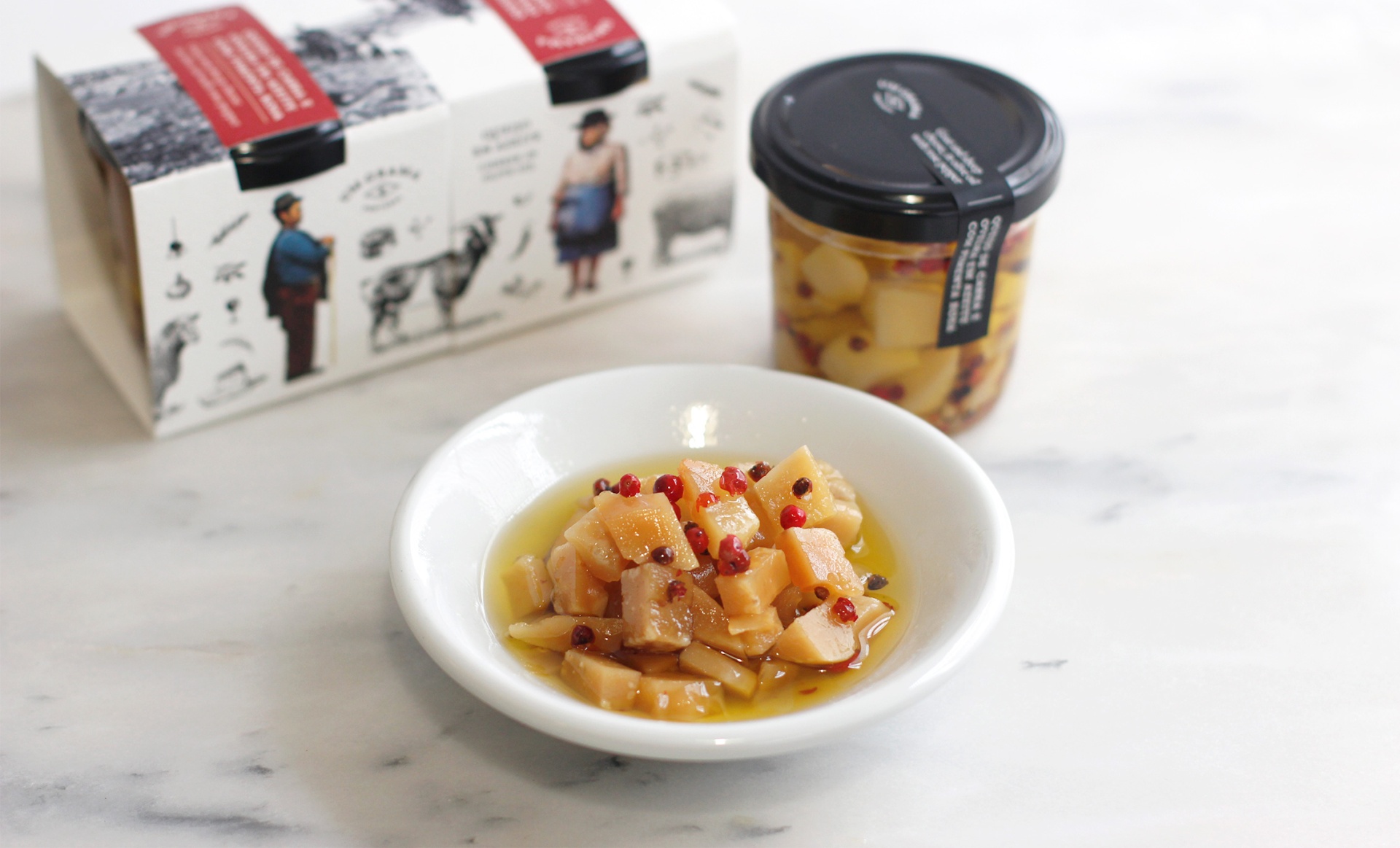 Frasco de vidro com produto amarelo, prato branco com pedaços do produto e caixa ilustrada em fundo branco