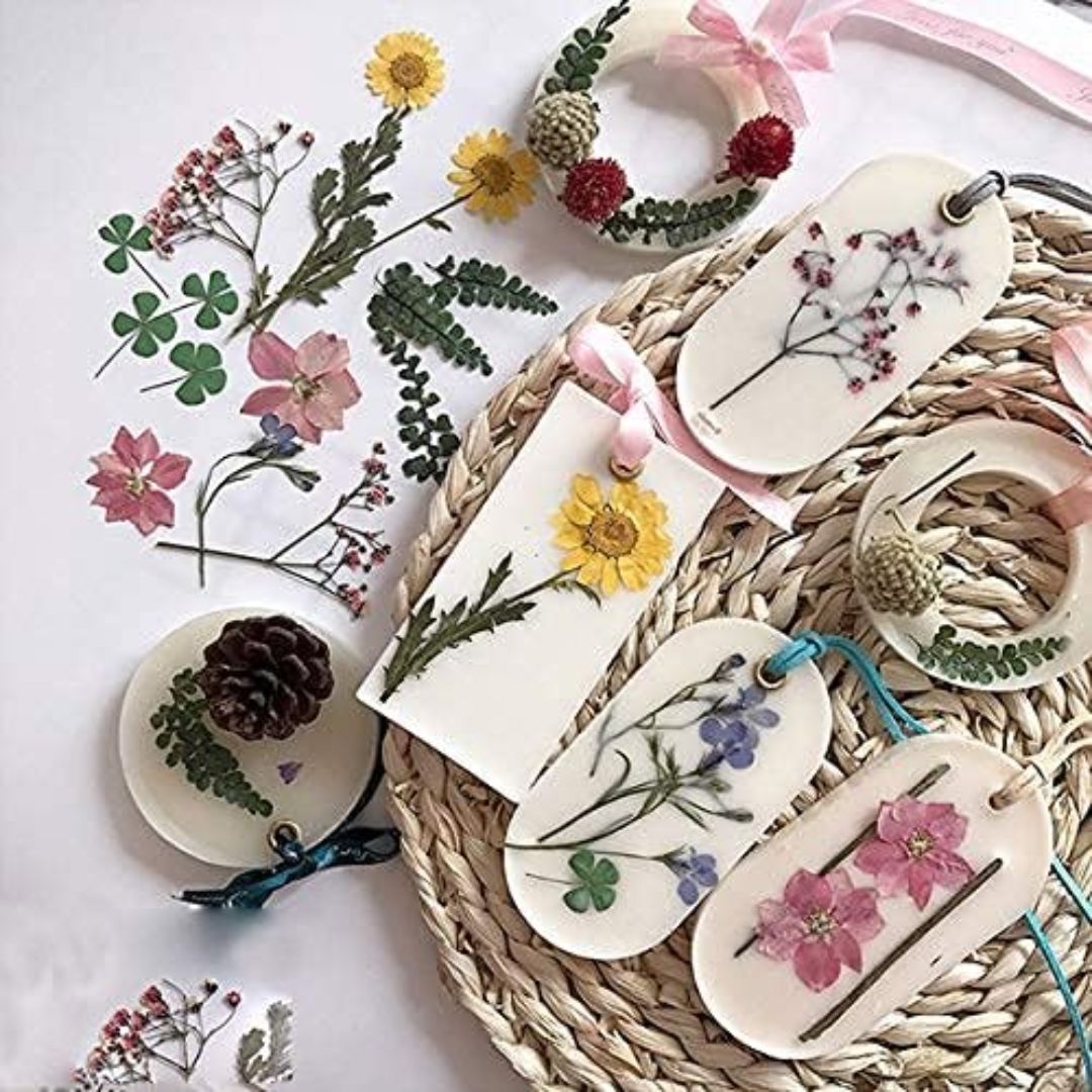 Saquetas aromáticas com flores prensadas e laços sobre base de ráfia