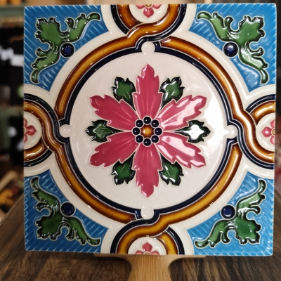 Azulejo cerâmico quadrado com padrão floral colorido e relevo