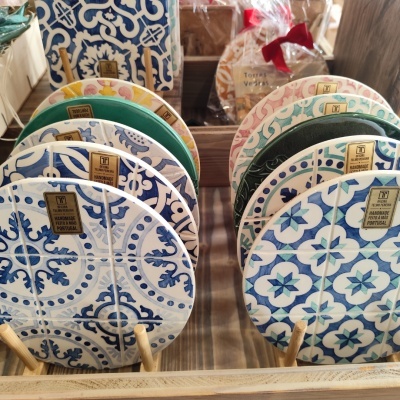 Azulejos redondos feitos à mão com diferentes padrões coloridos em suporte de madeira