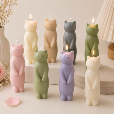 Velas coloridas em forma de gato em diferentes posições sobre uma mesa clara