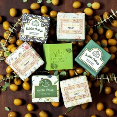 Sabonetes embalados coloridos da marca Sabão Antigo e Essências de Portugal com frutos amarelos e folhas secas