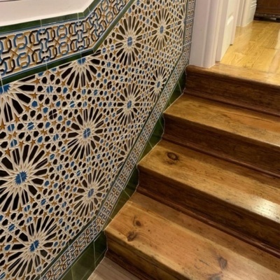 Escada de madeira com azulejos decorativos coloridos na parede