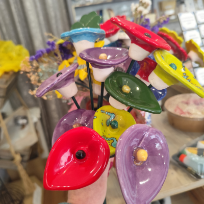 Bouquet colorido de flores decorativas em cerâmica numa mão