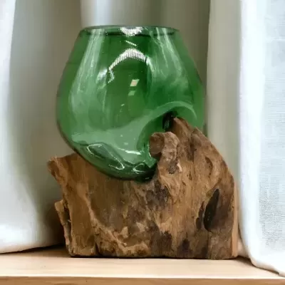 Vaso de vidro verde numa base de madeira rústica