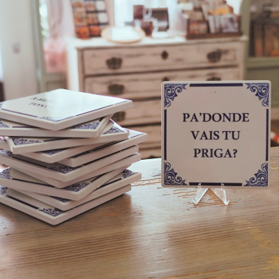 Azulejos decorativos brancos com texto em português numa mesa de madeira