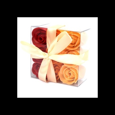 Conjunto de quatro sabonetes em forma de rosas em caixa transparente com fita de cetim creme.