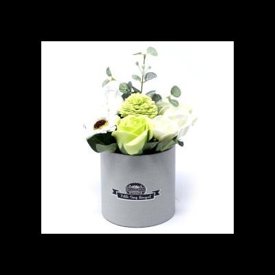 Arranjo de flores artificiais em vaso cinza com etiqueta preta e branca