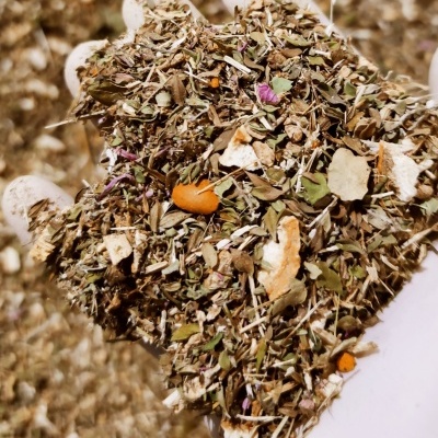 Mistura de ervas secas nas mãos com luva branca