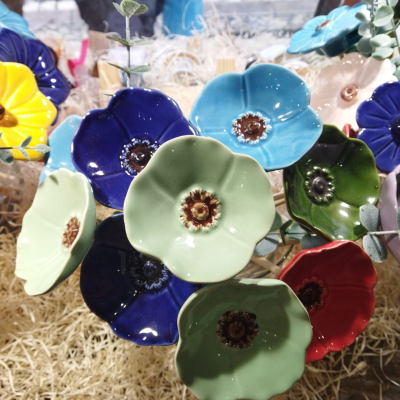 Flores decorativas em cerâmica colorida sobre palha