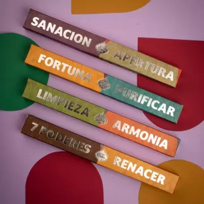 Quatro pacotes coloridos de incenso com textos em espanhol sobre cura, fortuna, limpeza, harmonia e renascimento