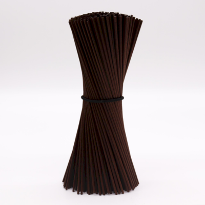 Conjunto de pauzinhos de madeira escura unidos por elástico preto em fundo branco