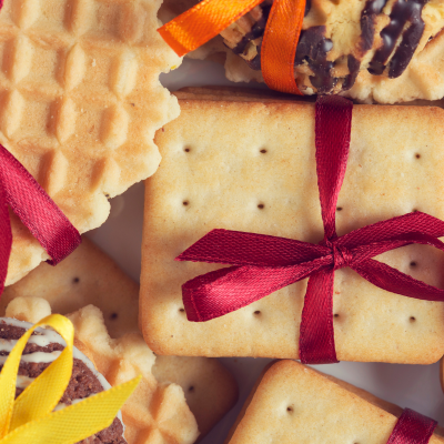Biscoitos sortidos com fitas coloridas amarradas em fundo branco
