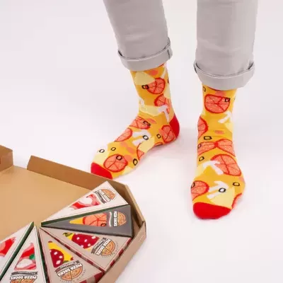 Meias amarelas com padrão de laranja e embalagens triangulares coloridas num fundo branco