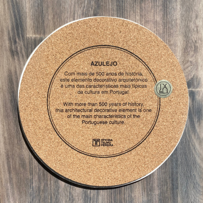 Disco redondo de cortiça com texto impresso sobre azulejos em fundo de madeira