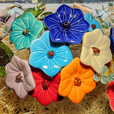 Flores decorativas em cerâmica colorida com caules e folhas artificiais
