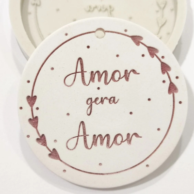 Disco redondo branco com texto 'Amor gera Amor' e corações vermelhos