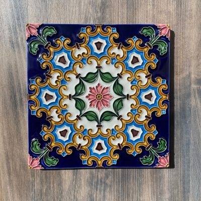 Azulejo cerâmico decorativo com padrão floral colorido em fundo azul escuro